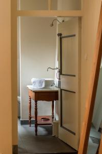 a bathroom with a sink and a table with a mirror at Hotel Noorderhoofd in Veere +230 photos