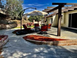 un patio con mesa, sillas y sombrilla en Santa Clarita Mountain Top, en Santa Clarita