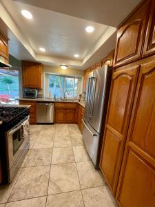 a kitchen with wooden cabinets and a stainless steel refrigerator at Santa Clarita Mountain Top in Santa Clarita