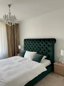 Un dormitorio con una cama grande y una lámpara de araña. en Duke’s House en Bistriţa