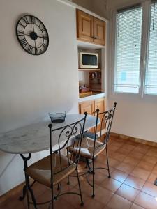 アルルにあるAppartement de 2 chambres avec vue sur la ville et wifi a Arlesのキッチン(テーブル、椅子、壁掛け時計付)