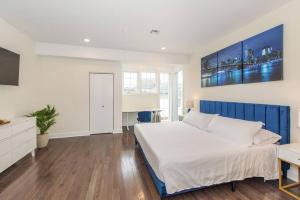 a bedroom with a large white bed and a tv at Modern Condo-NYC@Fingertips in North Bergen