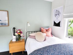 a bedroom with a bed with pink pillows at Inner City Sunny Bedroom in Auckland