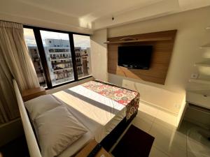 ein Schlafzimmer mit einem Bett und einem großen Fenster in der Unterkunft Venice Park Hplus Long Stay in Brasilia + 44 Fotos