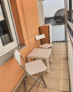 two chairs and a table on a balcony at R&S Apartment in Graz