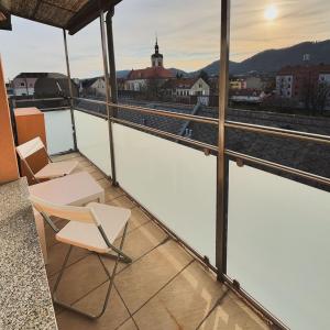 a balcony with chairs and a view of a city at R&S Apartment in Graz