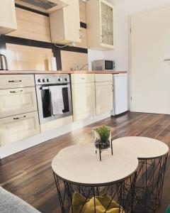 a kitchen with a table and a kitchen with white cabinets at R&S Apartment in Graz