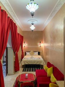 馬拉喀什的住宿－Riad La Bigarade，一间卧室配有一张床和一张红色的沙发