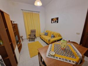 Al Manzil في Locogrande: غرفة معيشة مع أريكة صفراء وطاولة