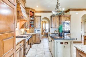 a large kitchen with wooden cabinets and a sink at Spacious Edmond Vacation Rental with Shared Pool! in Edmond