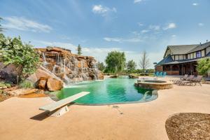 a swimming pool with a waterfall in a backyard at Spacious Edmond Vacation Rental with Shared Pool! in Edmond