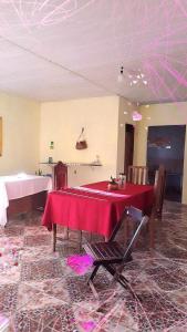 une salle à manger avec une table et des chaises rouges dans l'établissement Pousda kurasi alter, à Alter do Chão