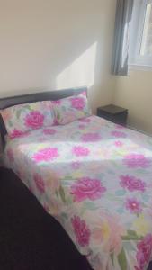 a bed with a floral comforter in a bedroom at Budget Rooms in Fort William