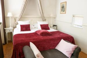 - une chambre avec un grand lit et une couverture rouge dans l'établissement Auberge de Campveerse Toren, à Veere