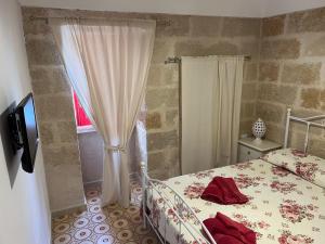 een slaapkamer met een bed en een raam bij BOUCANVILLE in Polignano a Mare