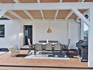 eine Terrasse mit einem Tisch, Stühlen und einem Grill in der Unterkunft FeelGood 212 qm Ferienhaus mit 2 Apartments - Garten, Grill & Sauna! in Schauenburg