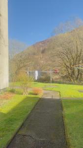 een loopbrug in een park met een heuvel op de achtergrond bij Budget Rooms in Fort William