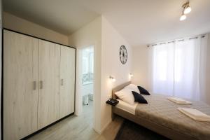 a bedroom with a large bed and a large closet at Piccola Pyrotima in Zadar