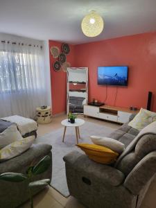 a living room with a couch and a tv on a wall at Experience Nairobi in Nairobi