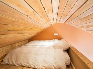 Cama en habitación con techo de madera en 2 bedrooms house with terrace and wifi at Modave, en Modave