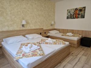 two beds in a hotel room with towels on them at Apartment and Rooms Amenka in Novalja