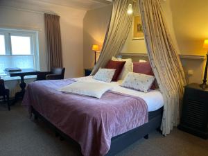 - une chambre avec un lit à baldaquin dans l'établissement Auberge de Campveerse Toren, à Veere