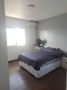 a bedroom with a bed in a white room at De boa na Lagoa. in São Lourenço do Sul