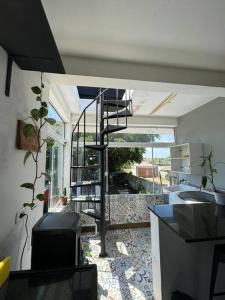 a living room with a spiral staircase in a house at De boa na Lagoa. in São Lourenço do Sul