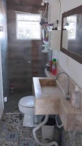 a bathroom with a white toilet and a sink at De boa na Lagoa. in São Lourenço do Sul