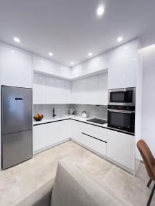 a white kitchen with white cabinets and appliances at AleNi City Apartment 1 in Rhodes Town