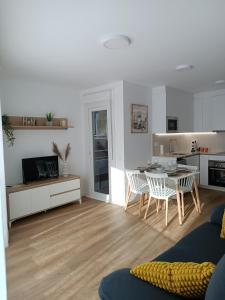 a kitchen and living room with a table and chairs at Andmar Beach Apartamento in Peñíscola