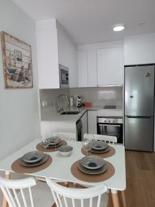 uma cozinha com uma mesa com pratos e copos de vinho em Andmar Beach Apartamento em Peñíscola