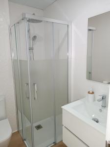 a bathroom with a glass shower and a sink at Andmar Beach Apartamento in Peñíscola