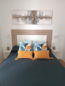 a bedroom with a blue bed with two pillows at Andmar Beach Apartamento in Peñíscola