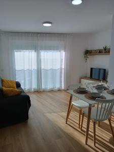 a living room with a table and a couch at Andmar Beach Apartamento in Peñíscola