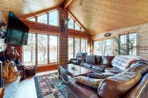 uma sala de estar com um sofá de couro e uma televisão em Log Cabin Life em Arkdale