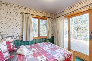 um quarto com uma cama e uma janela em Log Cabin Life em Arkdale