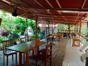 an outdoor patio with tables and chairs and a table at Hostal Las Mariposas Minca in Minca