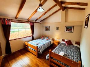 クスコにあるCabaña del Reyのベッドルーム1室(ベッド2台、窓付)