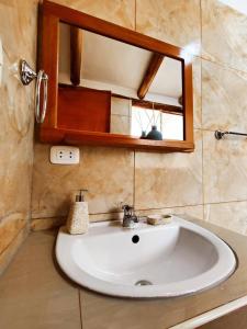 La salle de bains est pourvue d'un lavabo blanc et d'un miroir. dans l'établissement Cabaña del Rey, à Cusco