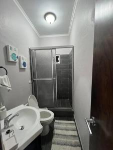 uma casa de banho com um chuveiro, um WC e um lavatório. em Casa Bonita em Puerto Cortes