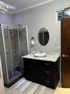 uma casa de banho com um lavatório e um chuveiro em Casa Bonita em Puerto Cortes