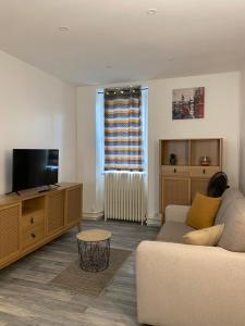 a living room with a couch and a flat screen tv at Verger - Parking gratuit - Calme in Chambéry