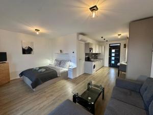 a bedroom with a bed and a living room at Scamard Apartman in Zamárdi