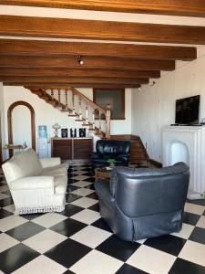 una sala de estar con muebles de cuero y una escalera. en Costa Esperanza MDQ en Mar del Plata