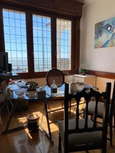 sala de estar con mesa, sillas y ventanas en Costa Esperanza MDQ en Mar del Plata
