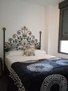 um quarto com uma cama grande e um cobertor preto e branco em Apartamento cerca del mar en Castellon em Grao de Castellón