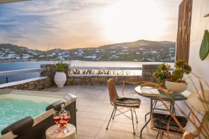 a balcony with a hot tub and a table and chairs at sunlight ornos suites, private hot tub in Mikonos