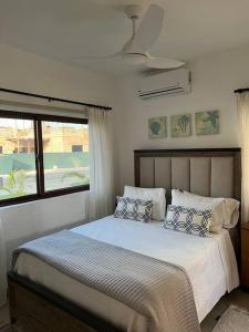 a bedroom with a bed with pillows and a window at Costal condo with gym and Olympic pool in Punta Cana +27 photos