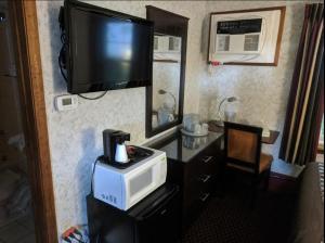 a room with a microwave and a television on the wall at Wagon Wheel Inn in Lenox